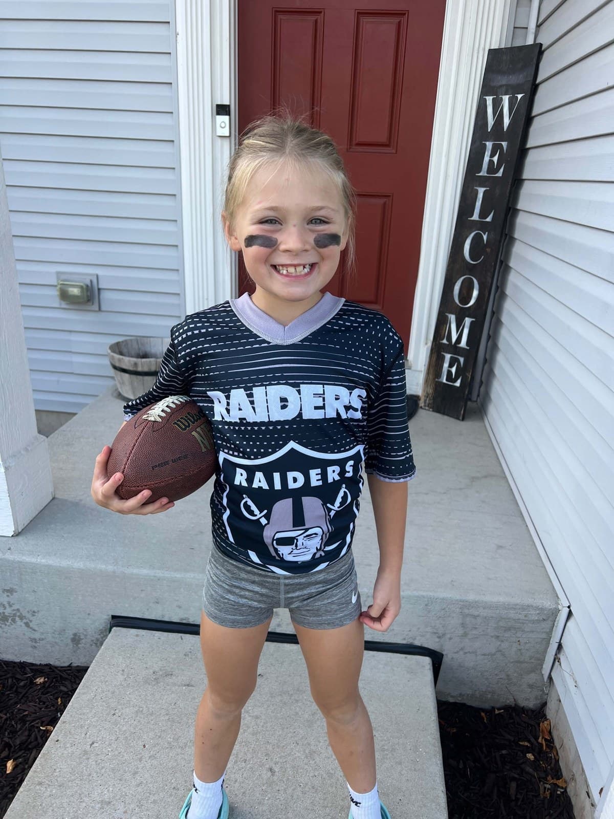 Sloane in her flag football jersey holding a football